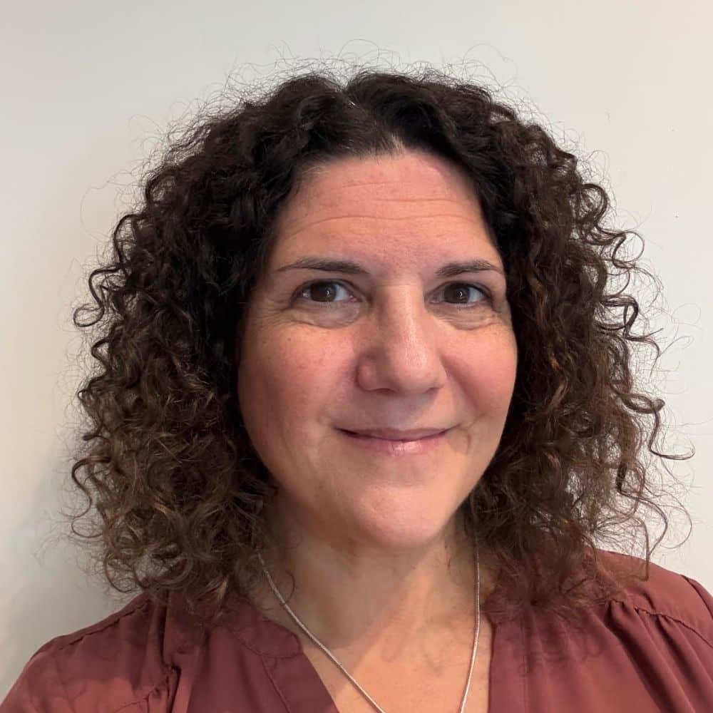 Person with curly hair, neutral expression.