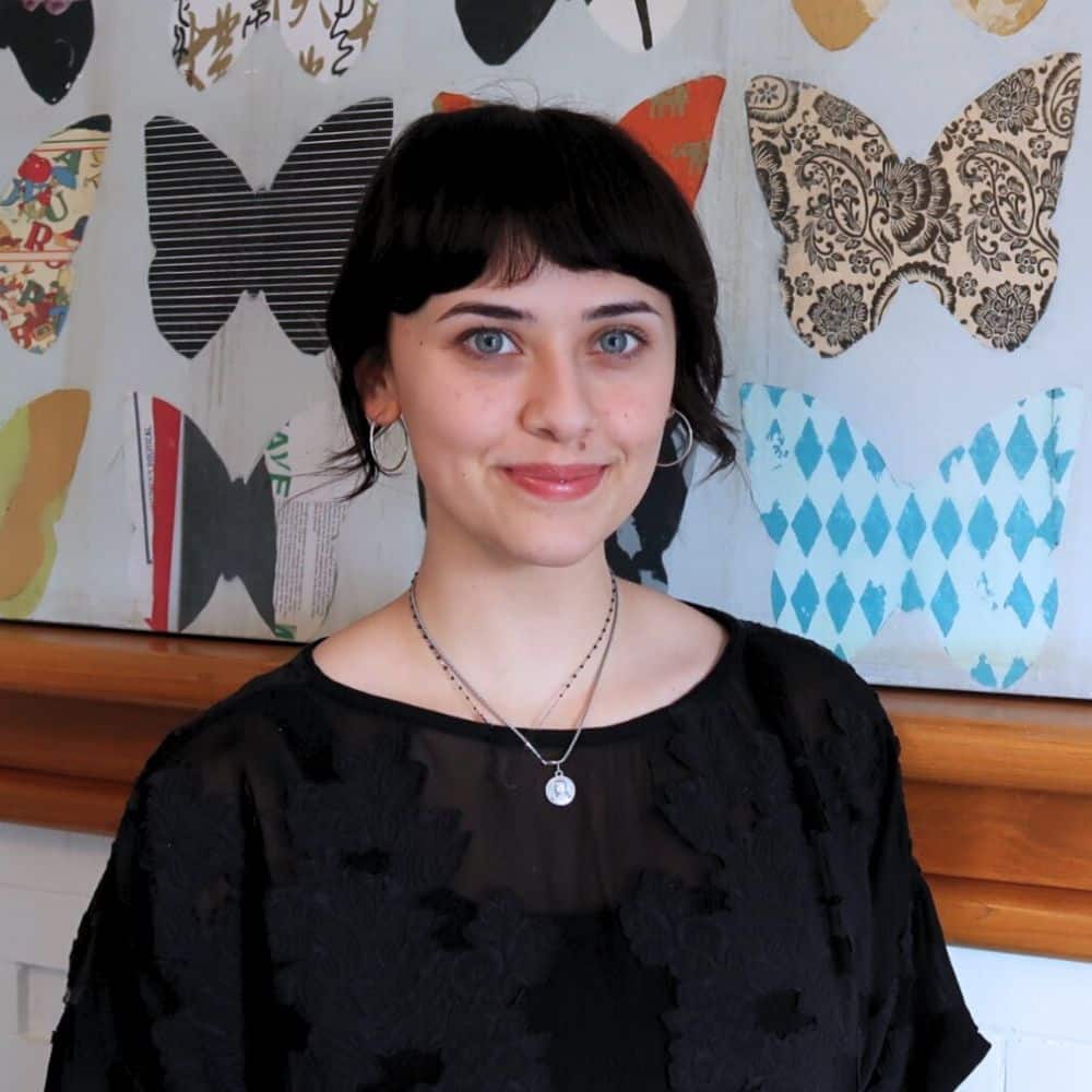 Person in front of patterned wall.