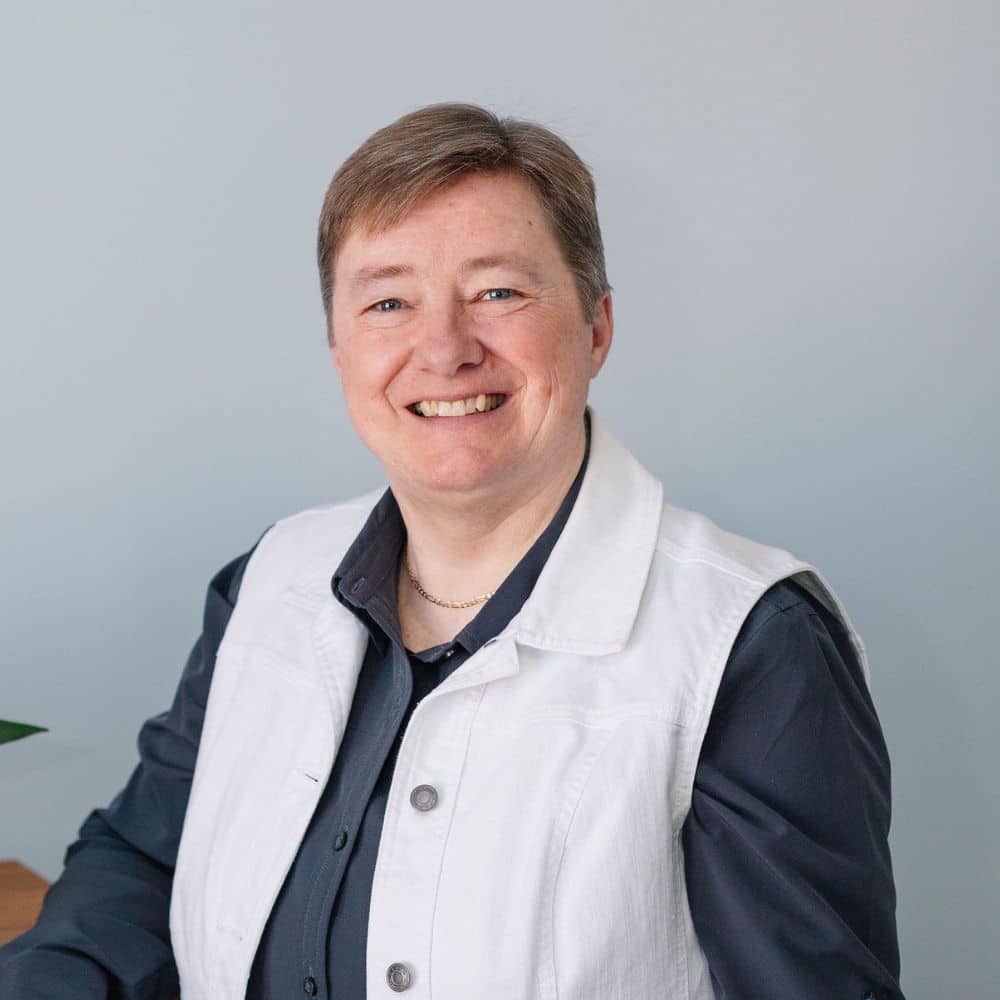 Person in white jacket seated.